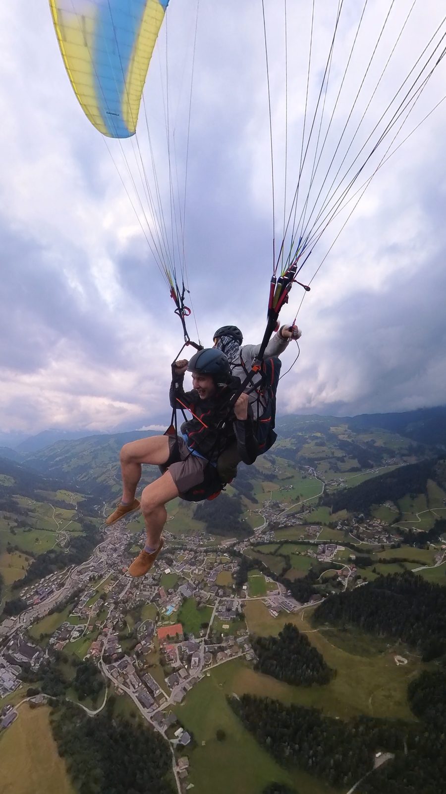 Duncan Bannon paragliding in tandem high above an alpine valley in Austria.